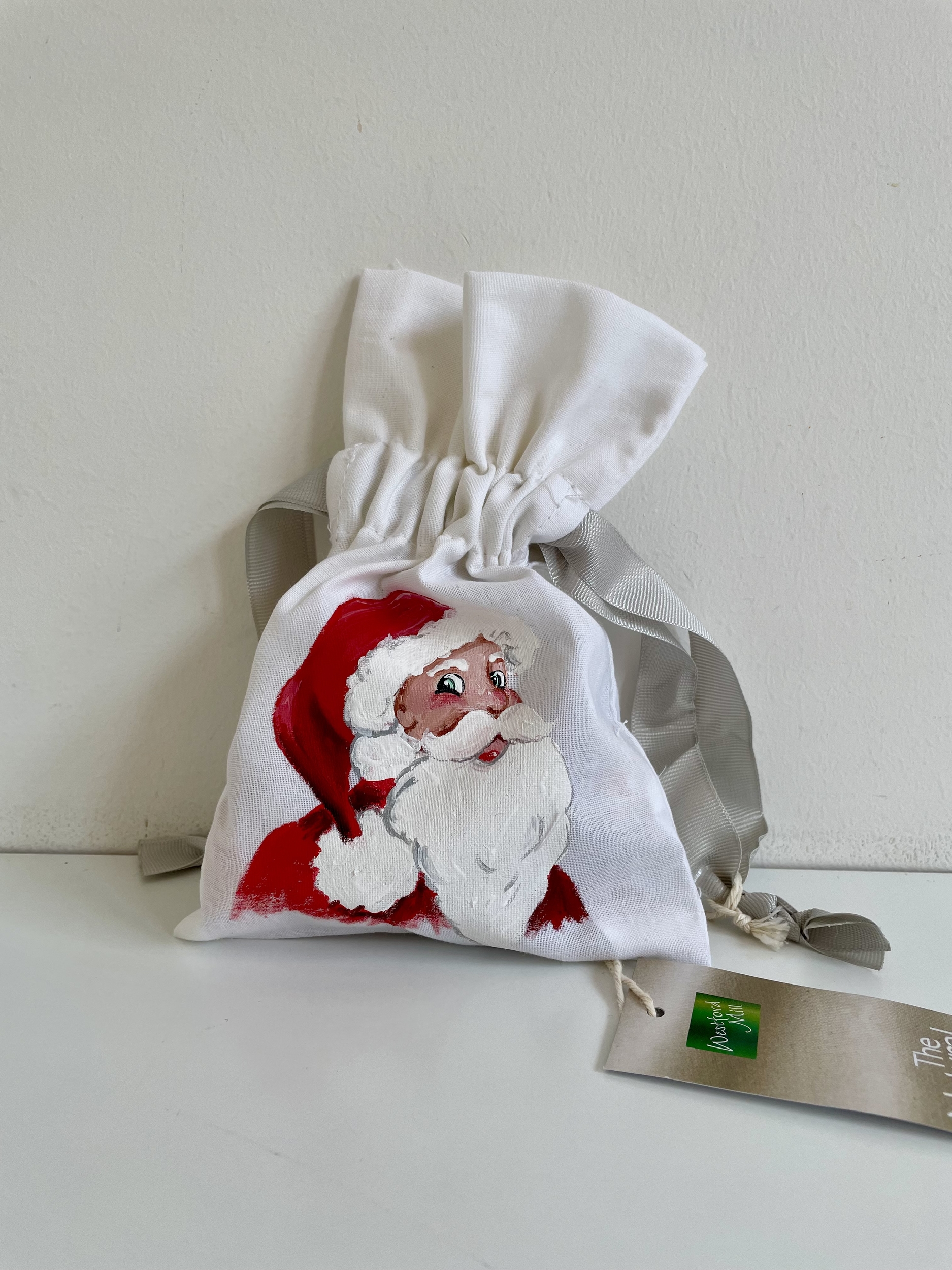 Pochette coton blanc, ruban satin gris, avec tête de père Noël peinte à la main par Elles et No.