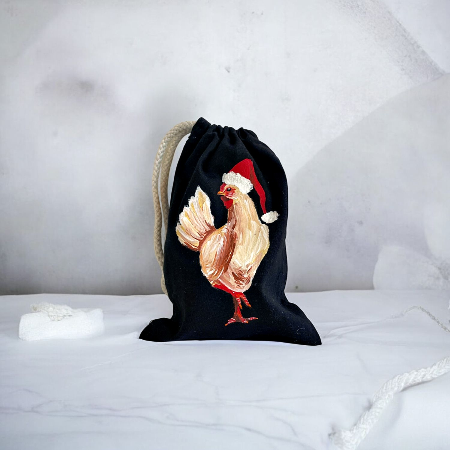 pochon coton noir avec poule coiffée dun bonnet de Père Noël peinte à la main par Elles et No.