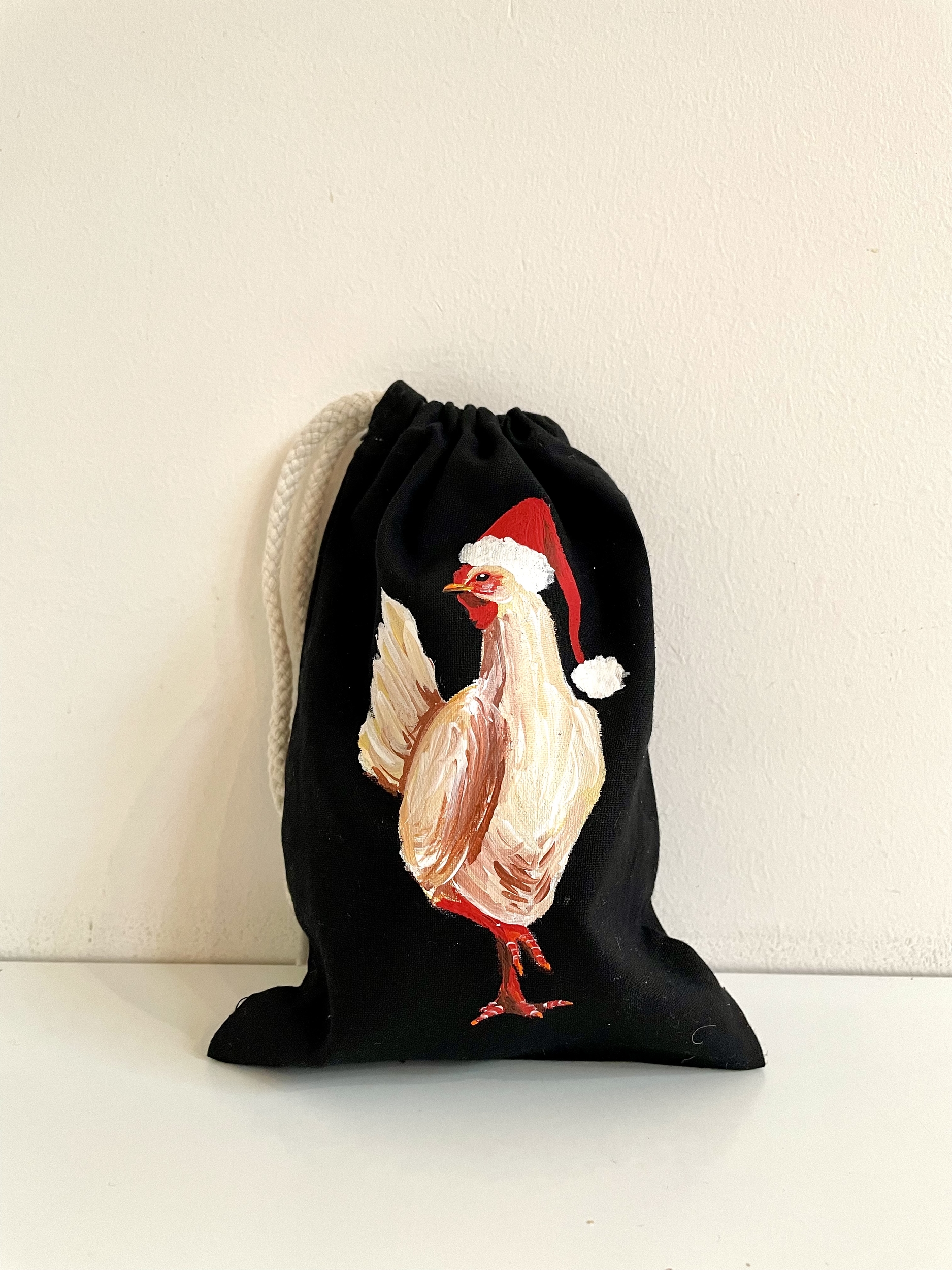 pochon coton noir avec poule coiffée dun bonnet de Père Noël peinte à la main par Elles et No.