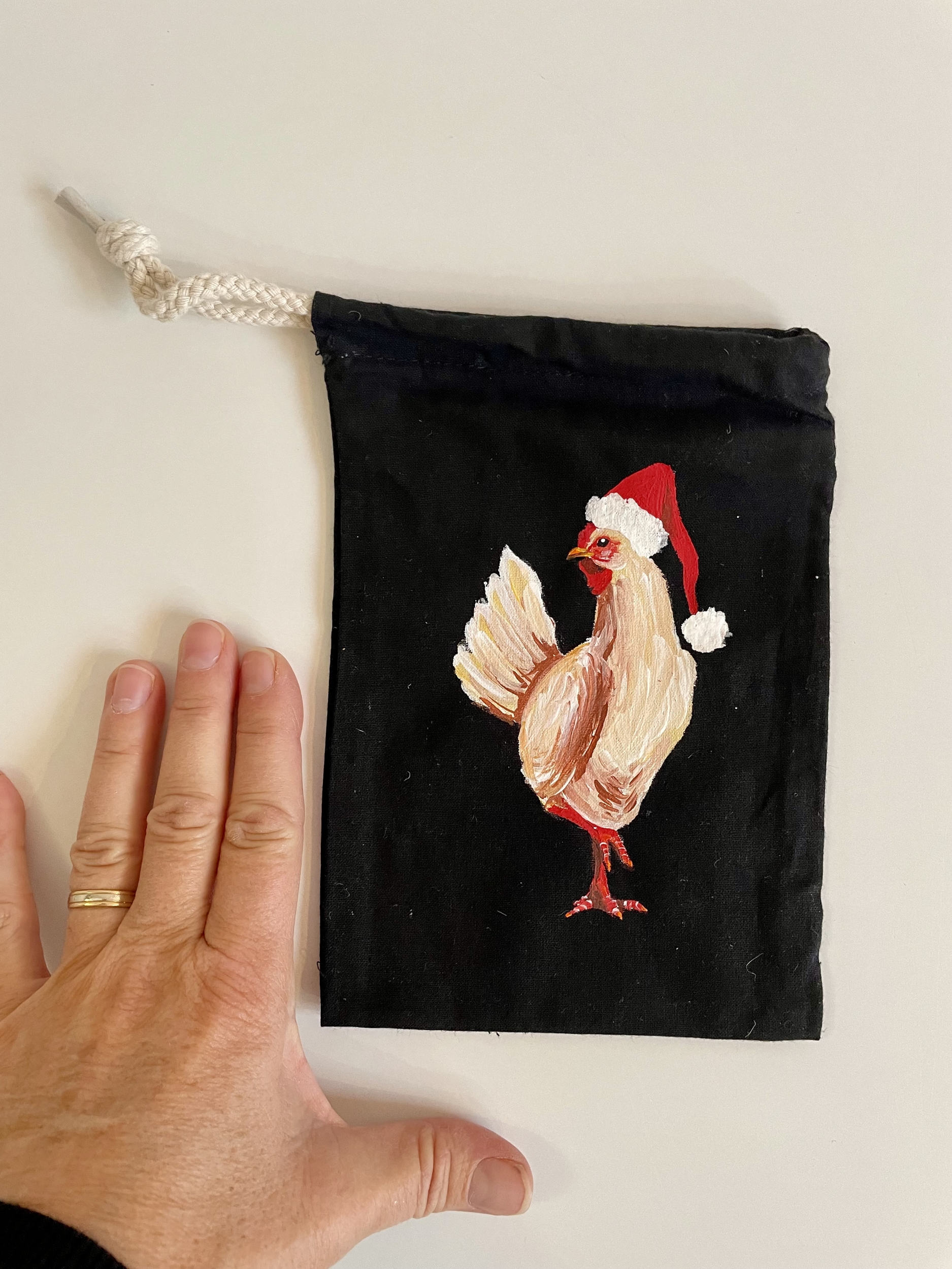 pochon coton noir avec poule coiffée dun bonnet de Père Noël peinte à la main par Elles et No.