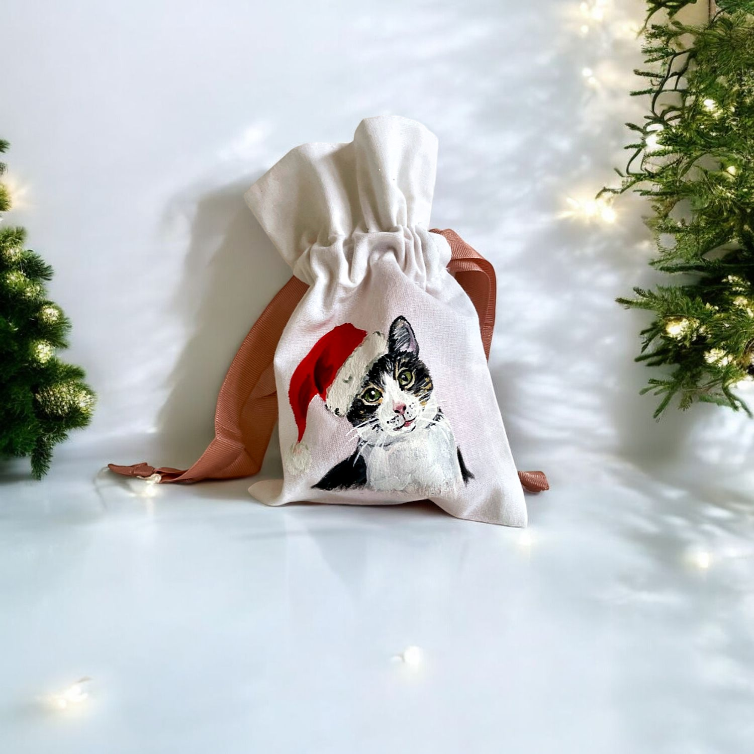 Pochon blanc en coton à cordon rose avec un chat coiffé dun bonnet de père Noël peint à la main par Elles et No.