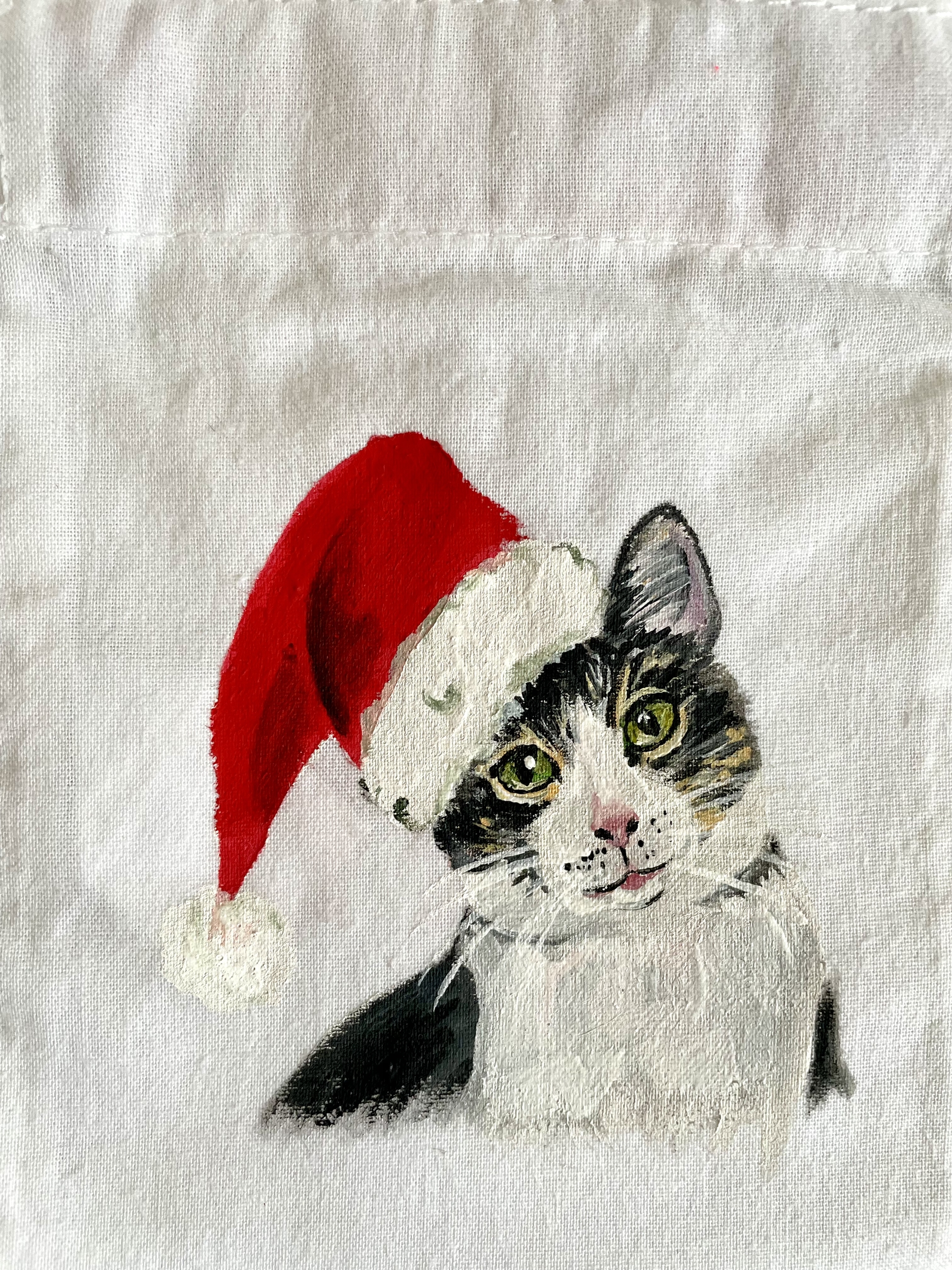 Pochon blanc en coton à cordon rose avec un chat coiffé dun bonnet de père Noël peint à la main par Elles et No.
