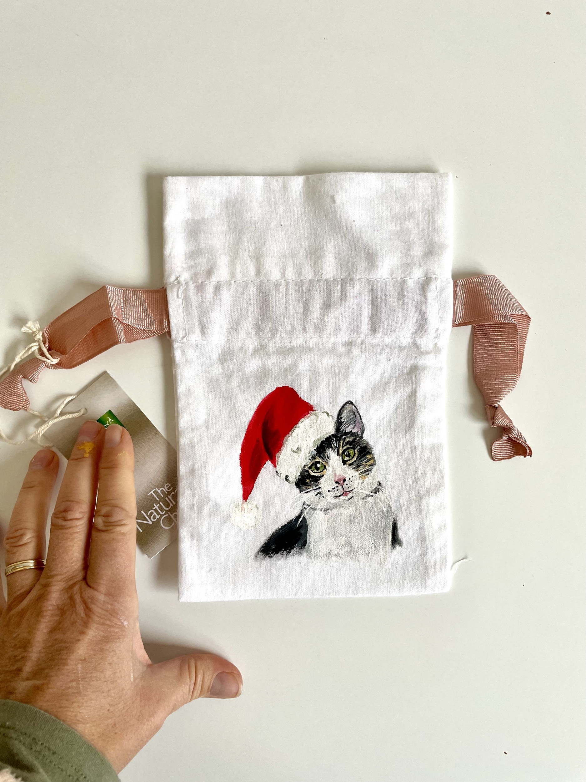 PPochon blanc en coton à cordon rose avec un chat coiffé dun bonnet de père Noël peint à la main par Elles et No.
