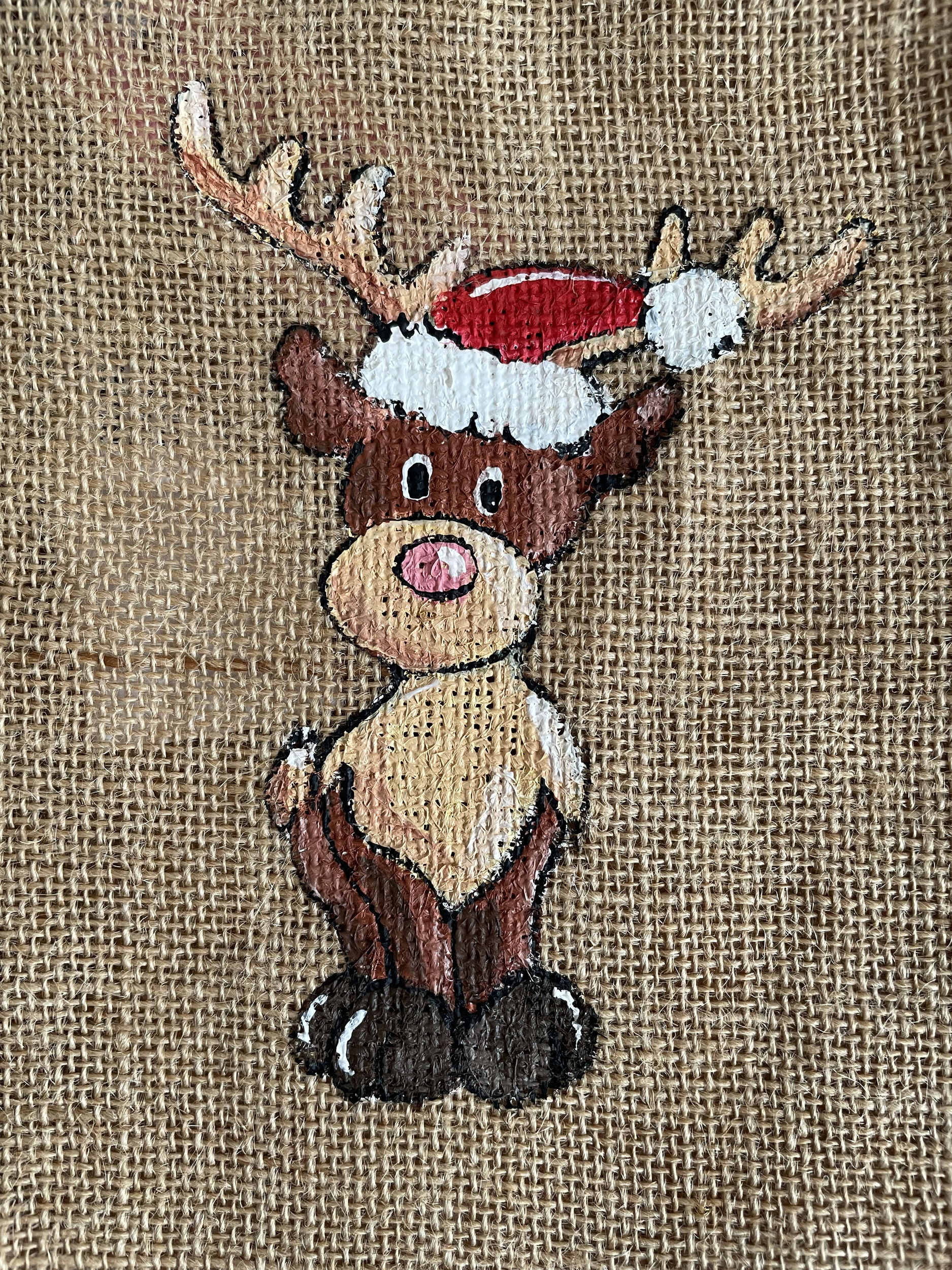 Pochon en jute avec un renne coiffé dun bonnet de père Noël peint à la main par Elles et No.