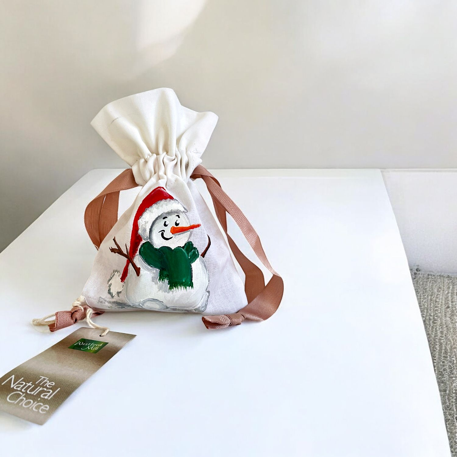 Pochon en coton blanc à ruban rose avec bonhomme de neige coiffé dun bonnet de père Noël, peint à la main par Elles et No.