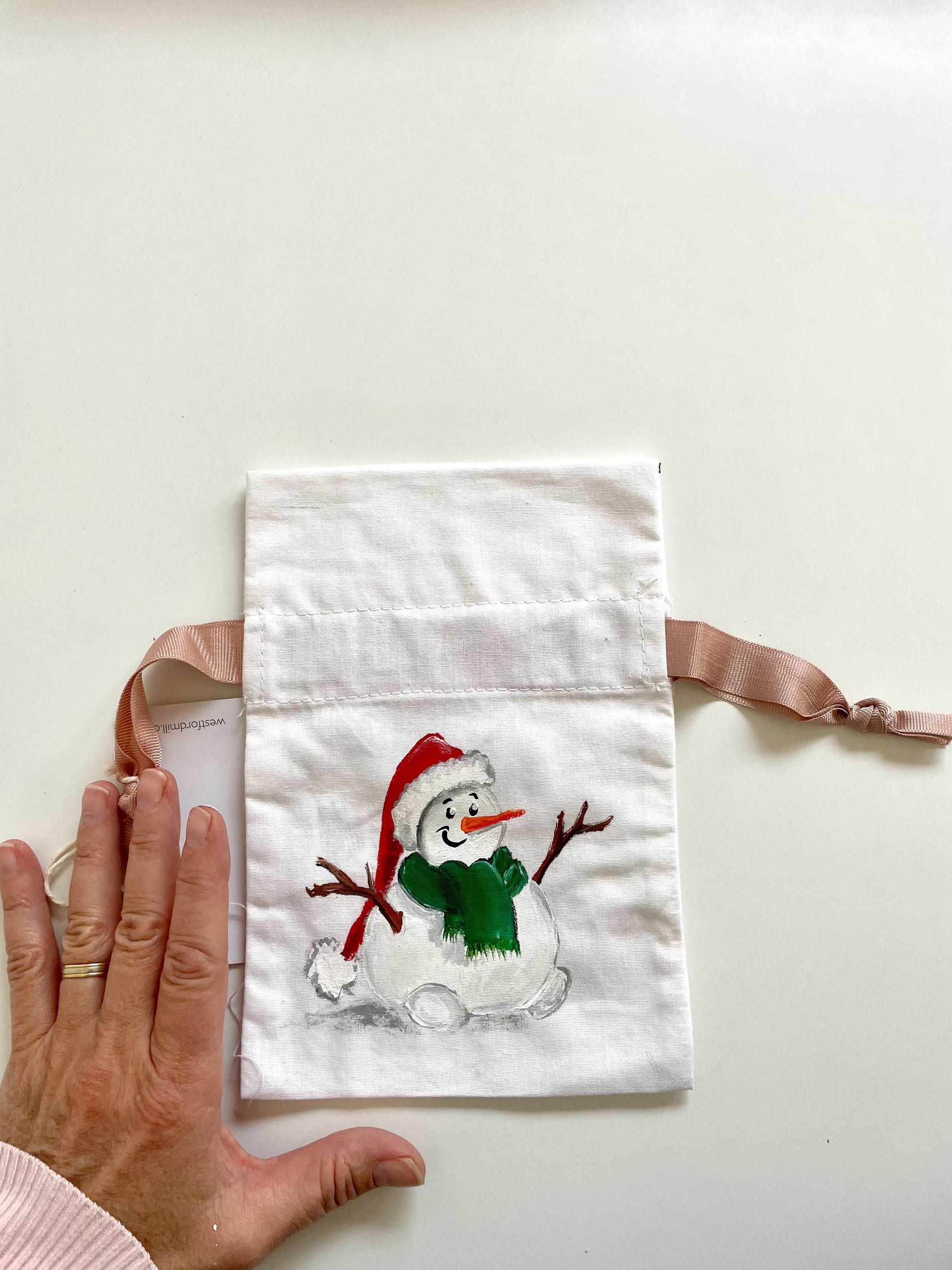 Pochon en coton blanc à ruban rose avec bonhomme de neige coiffé dun bonnet de père Noël, peint à la main par Elles et No.