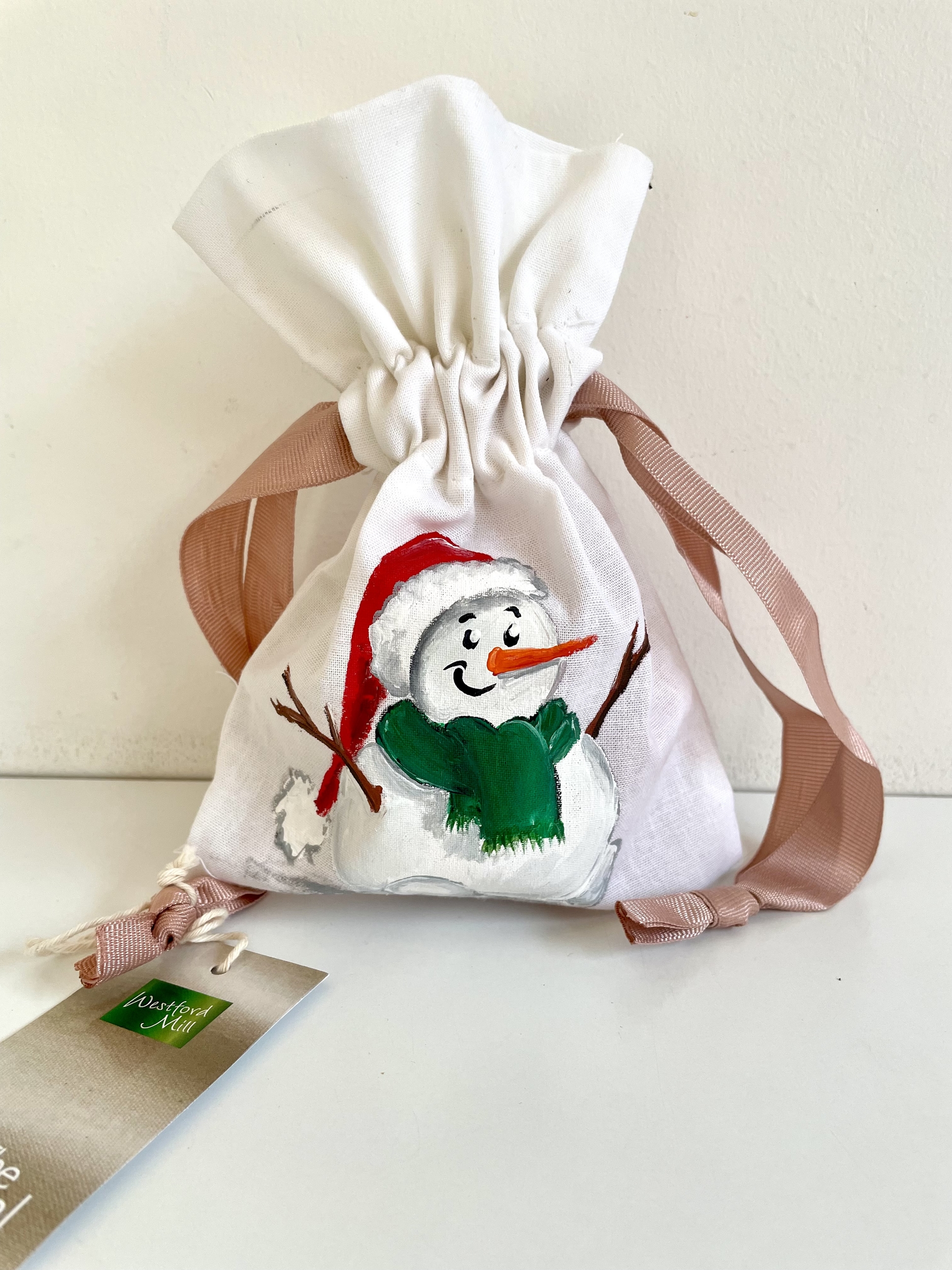 Pochon en coton blanc à ruban rose avec bonhomme de neige coiffé dun bonnet de père Noël, peint à la main par Elles et No.