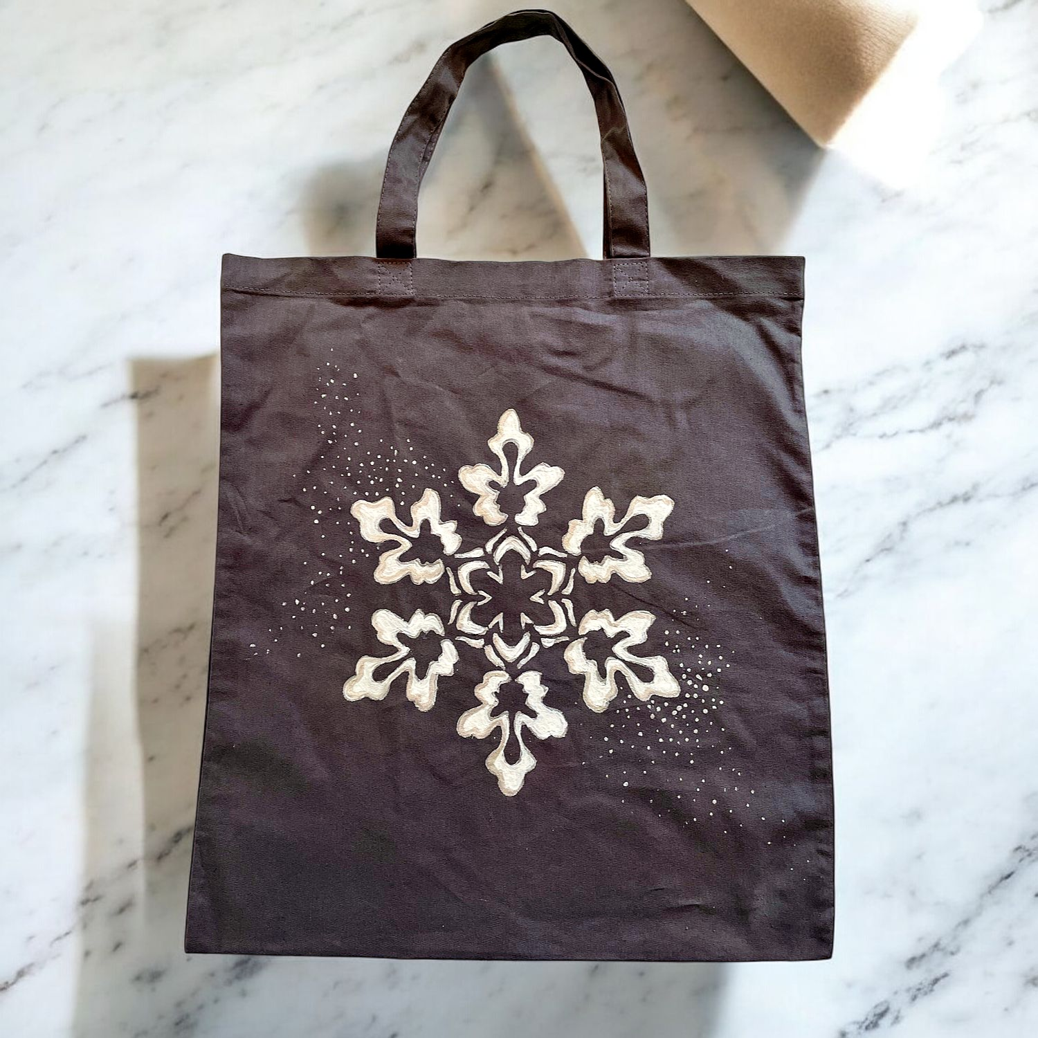 tote bag en coton gris à anses courtes avec un flocon de neige en gros plan peint. à la main