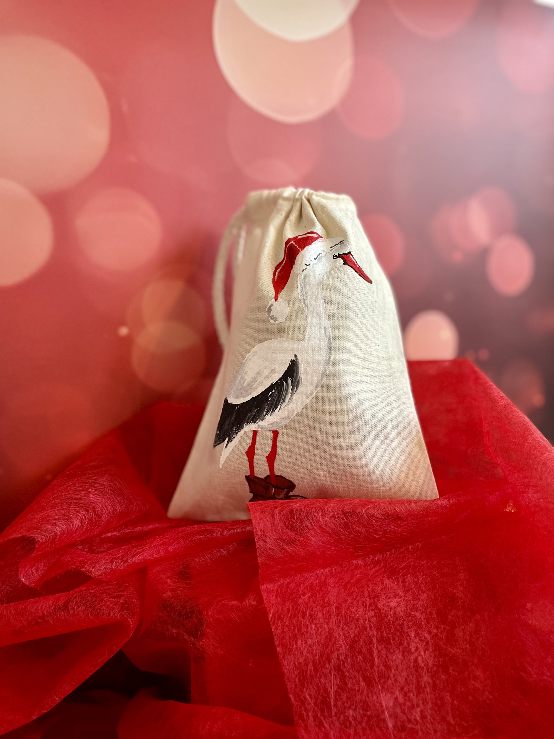 pochon en coton avec une cigogne portant un chapeau de Père Noël peinte à la main par Elles et No.