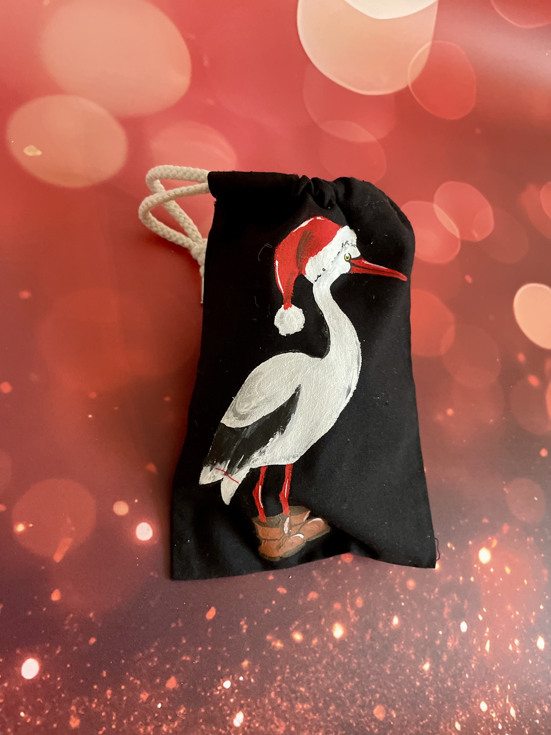 Ipochon en coton avec une cigogne portant un chapeau de Père Noël peinte à la main par Elles et No.