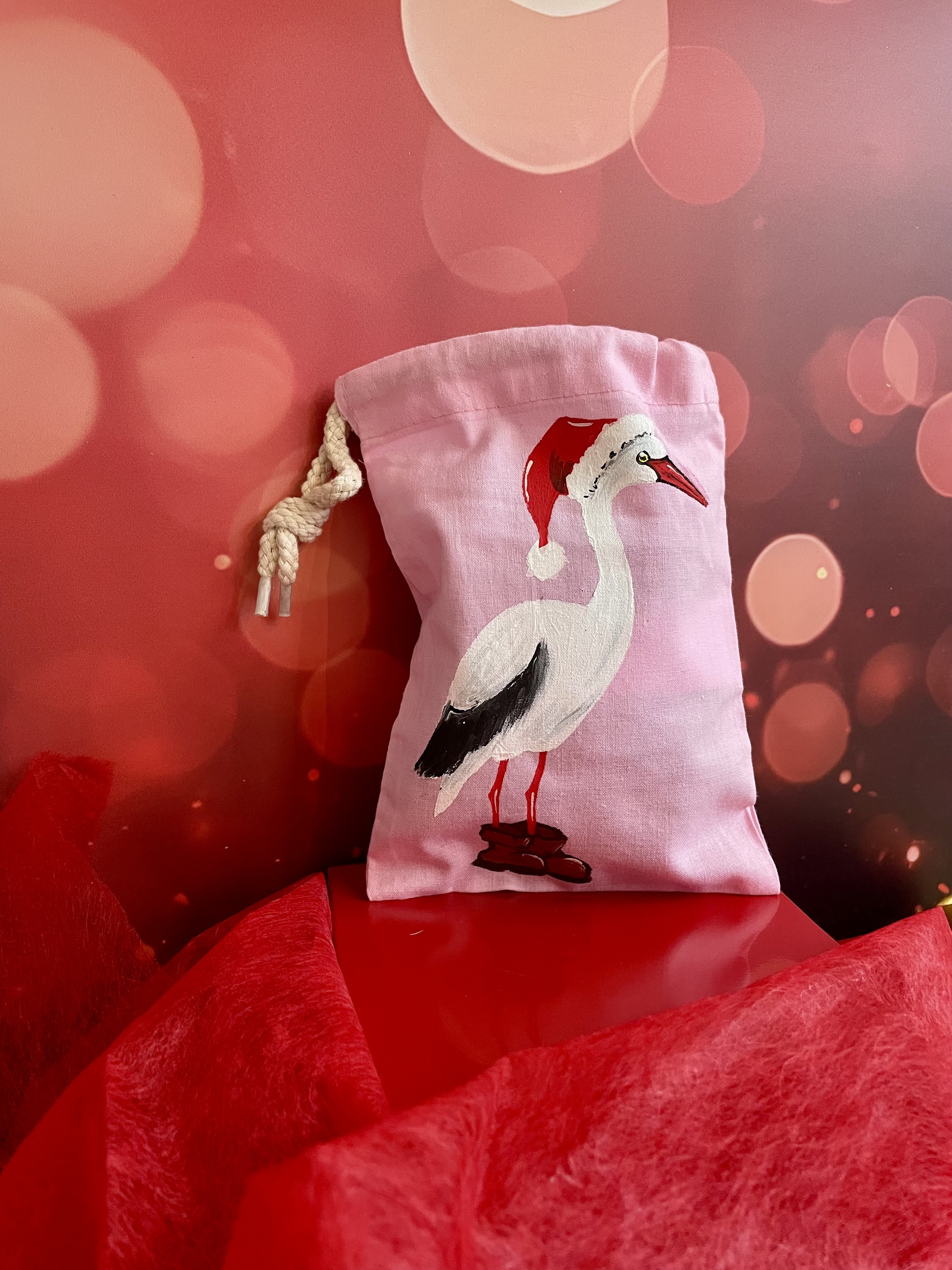 pochon en coton avec une cigogne portant un chapeau de Père Noël peinte à la main par Elles et No.