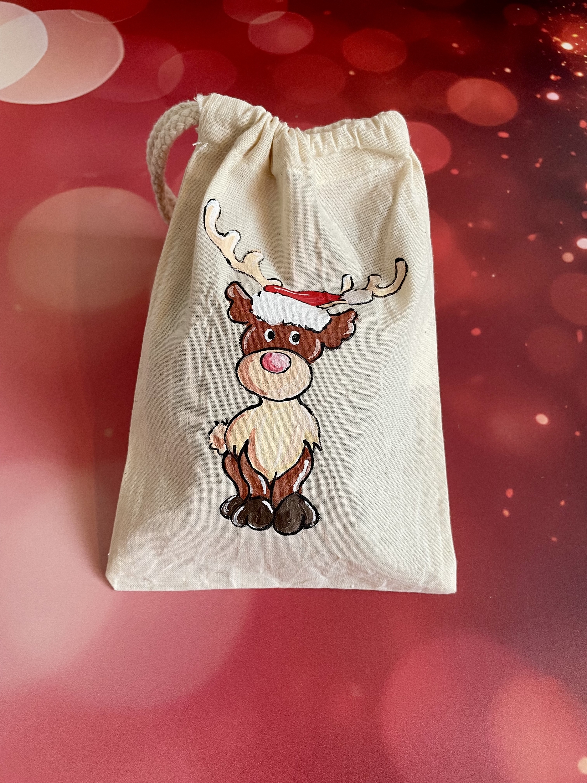 Pochon en coton beige avec un renne coiffé dun chapeau de Père Noël peint à la main par Elles et No.