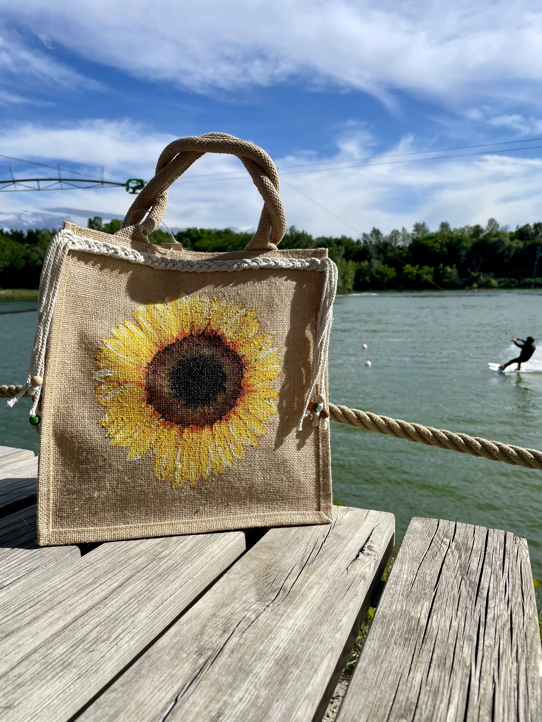 sac en jute avec un gros tournesol peint à la main par Elles et No. et un décor en macramé tressé et des perles.