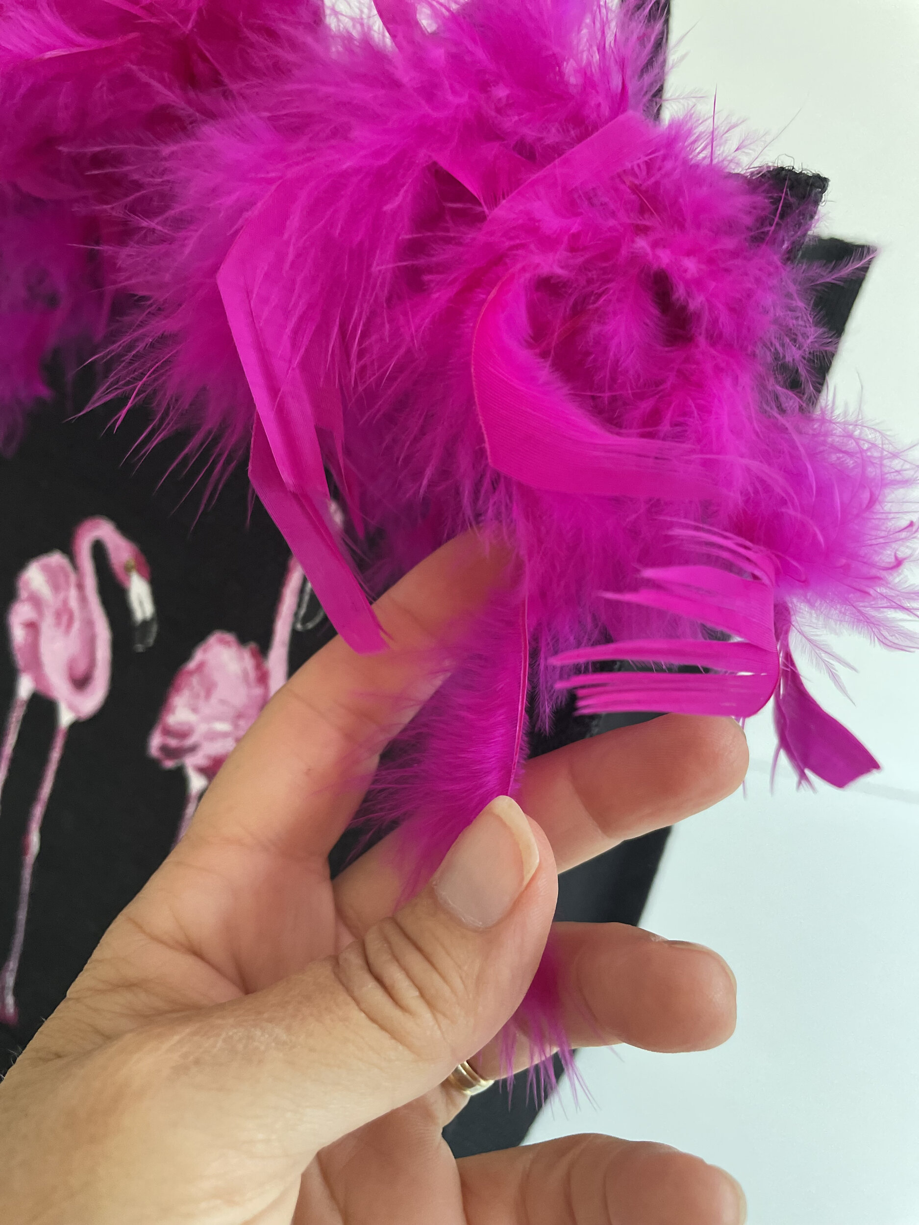 sac en jute noire avec des flamants roes peints à la main par Elles et No. et un boa rose en vraies plumes collé sur le bord du sac détail des plumes