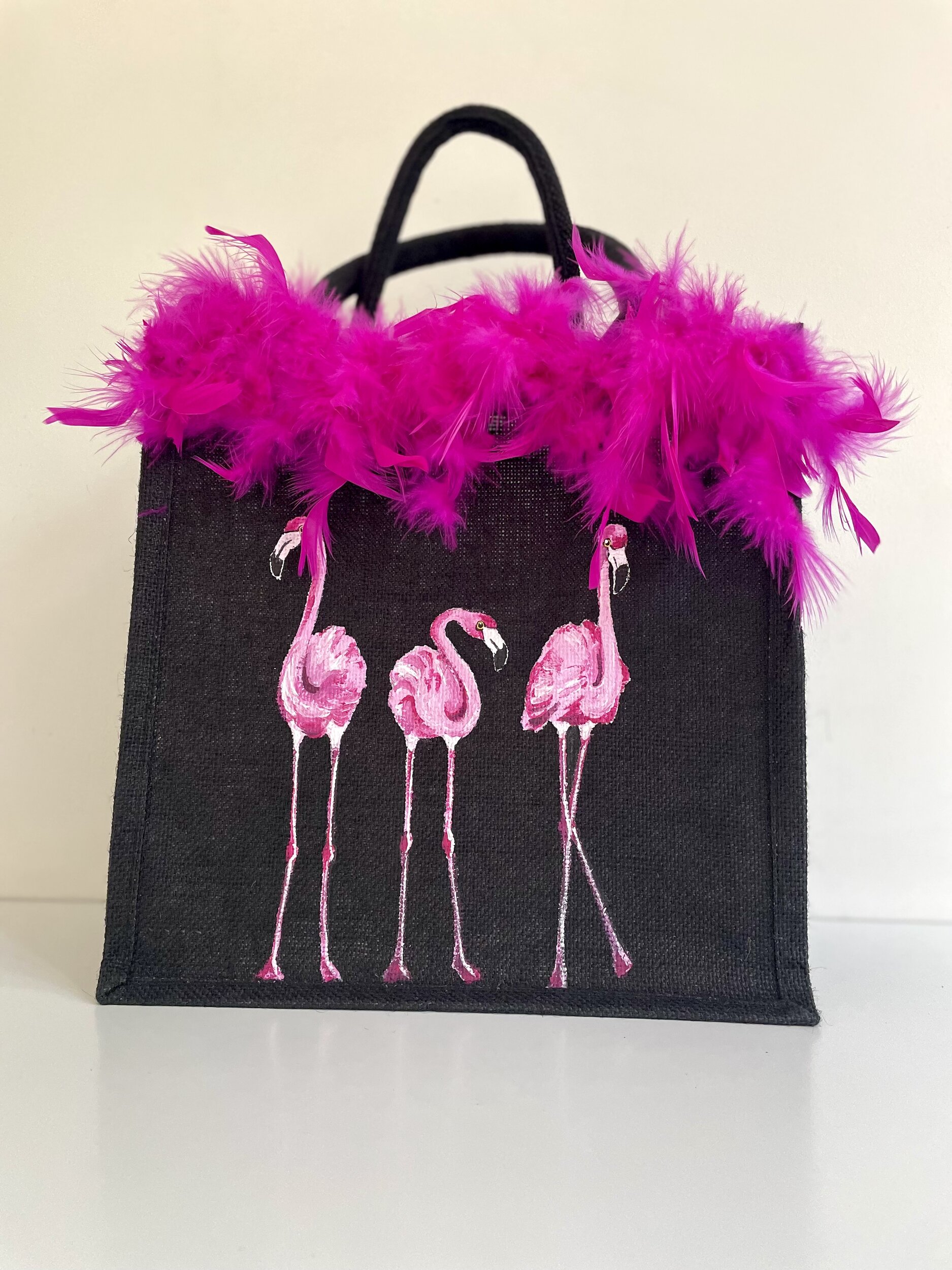 sac en jute noire avec des flamants roes peints à la main par Elles et No. et un boa rose en vraies plumes collé sur le bord du sac1