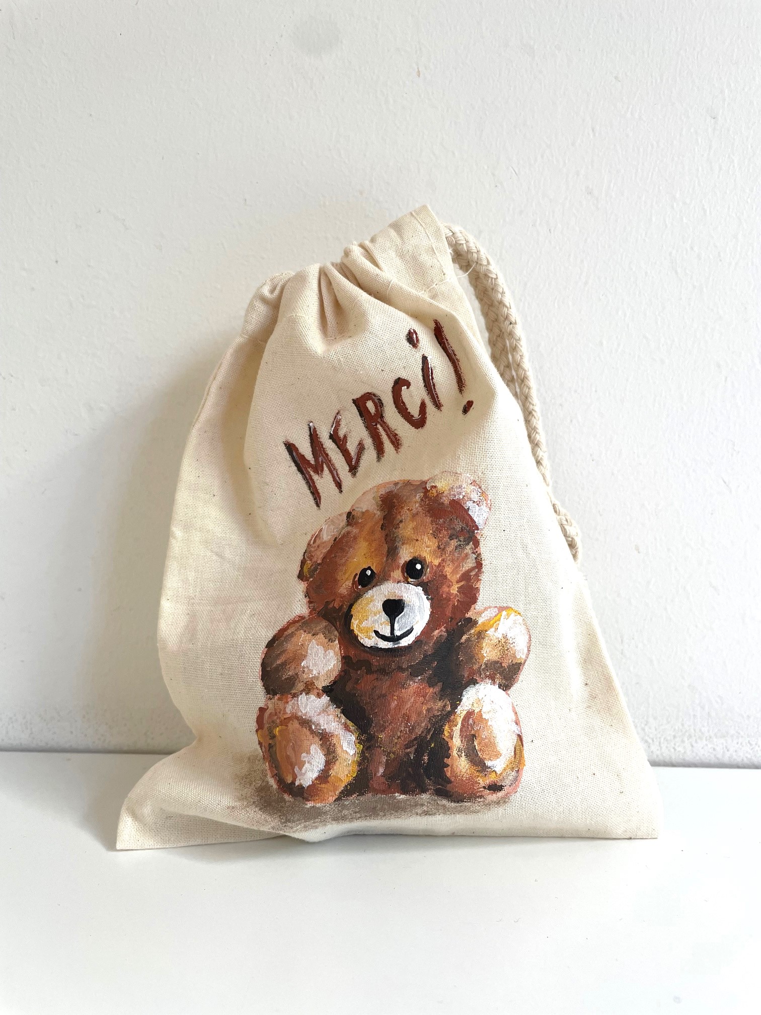 pochon beige avec un ourson et le mot merci peint a la main par elles et no