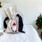 pochon en coton bio avec ruban satin noir avec un lutin de Noël rouge peint à la main par Elles et No.