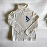 t-shirt col roulé blanc   Elles et No. avec un pingouin rigolo sur son snowboard, peint à la main