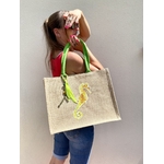 sac de plage en jute à anses vertes avec un hippocampe dans les tons jaune et vert peint à la main par Elles et No., présenté porté par une femme