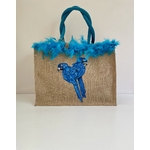 Sac de plage en jute avec des perroquets bleus peints à la main par Elles et No. et un boa en plumes collés sur le bord du sac