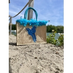 Sac de plage en jute avec des perroquets bleus peints à la main par Elles et No. et un boa en plumes collés sur le bord du sac