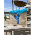 Sac de plage en jute avec des perroquets bleus peints à la main par Elles et No. et un boa en plumes collés sur le bord du sac