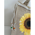sac en jute avec un tournesol peint à la main par Elles et No. et une tresse en macramé collée sur le bord supérieur du sac.