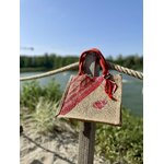 sac de plage en jute avec des rayures bayadère dans les tons rouges et un coquillage, peints à la main par Elles et No., présenté au bord de leau