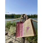 sac de plage en jute avec des rayures bayadère dans les tons roses et une méduse, peints à la main par Elles et No., présenté au bord de leau