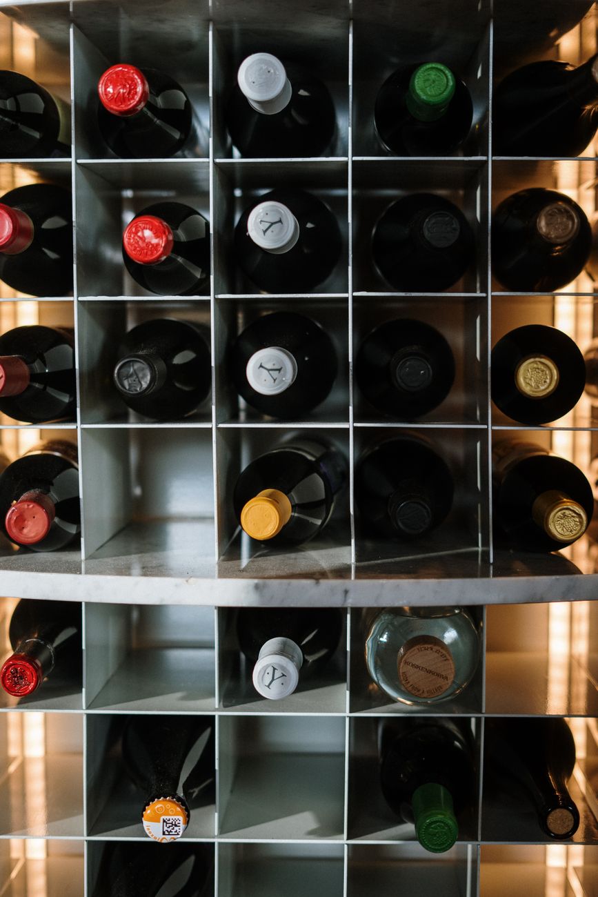 vue de dessus esthetique de bouteilles de vin assorties soigneusement rangees dans un support a etagere