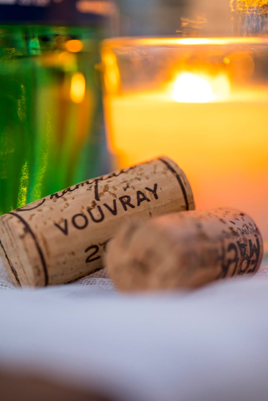 photo artistique de bouchons de vin a cote d une bougie allumee evoquant une ambiance chaleureuse et intime