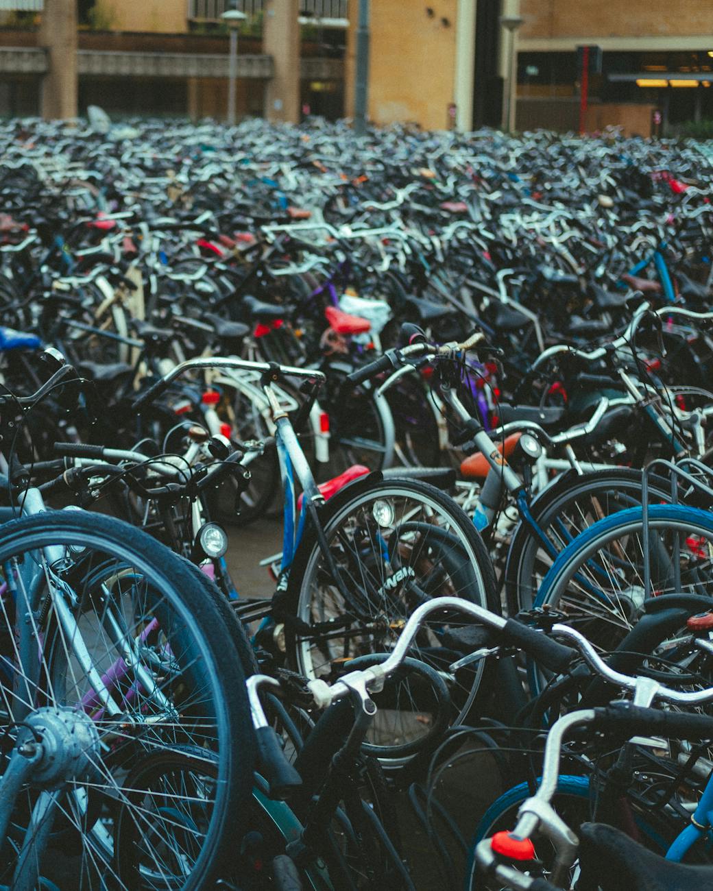 Des centaines de vélos garés dans une zone urbaine extérieure, créant une scène dense et dynamique