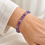 Bracelet en améthyste à perles rondes de 6 mm porté au poignet