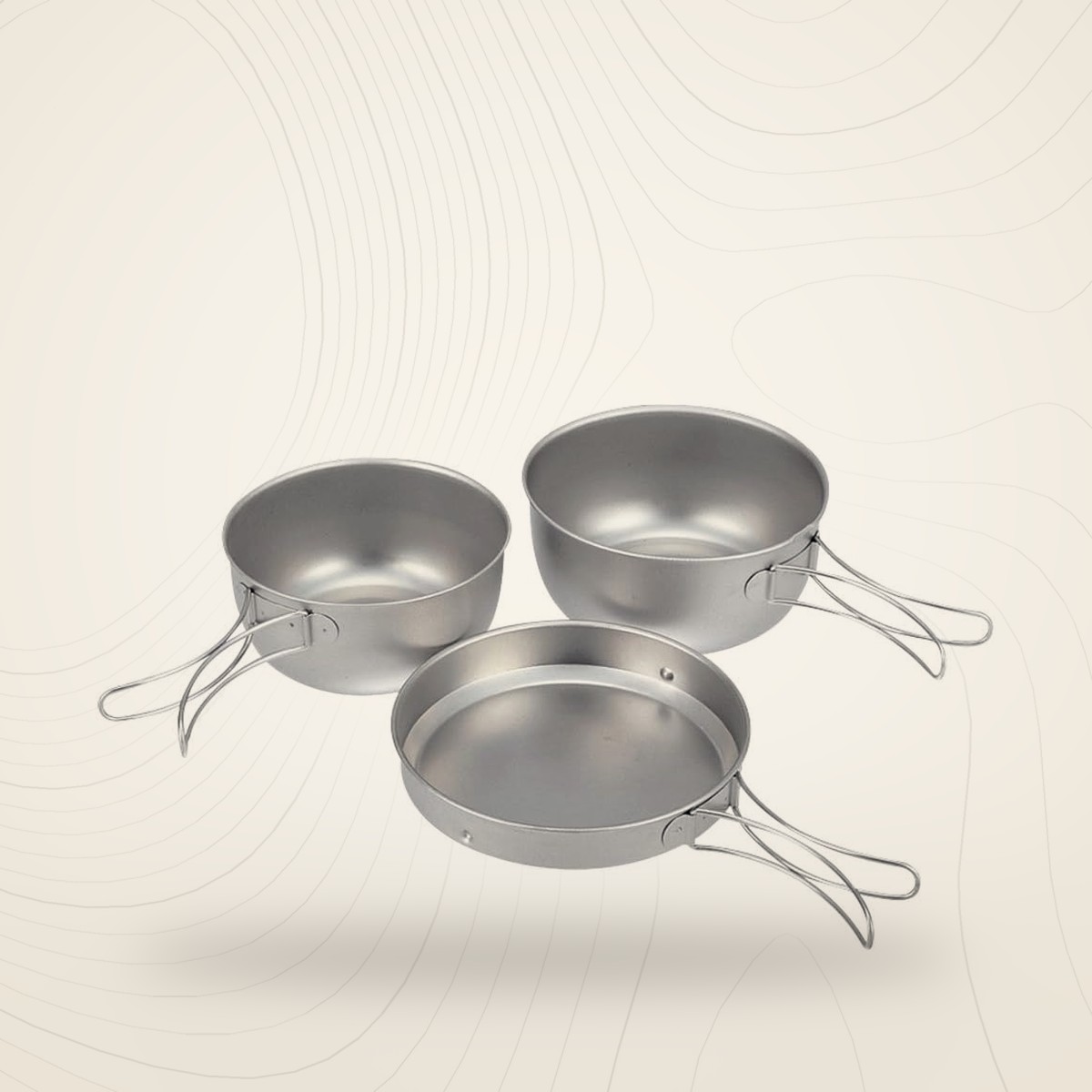Ensemble popote titane Snow Peak : deux casseroles et une poêle, sur fond lin