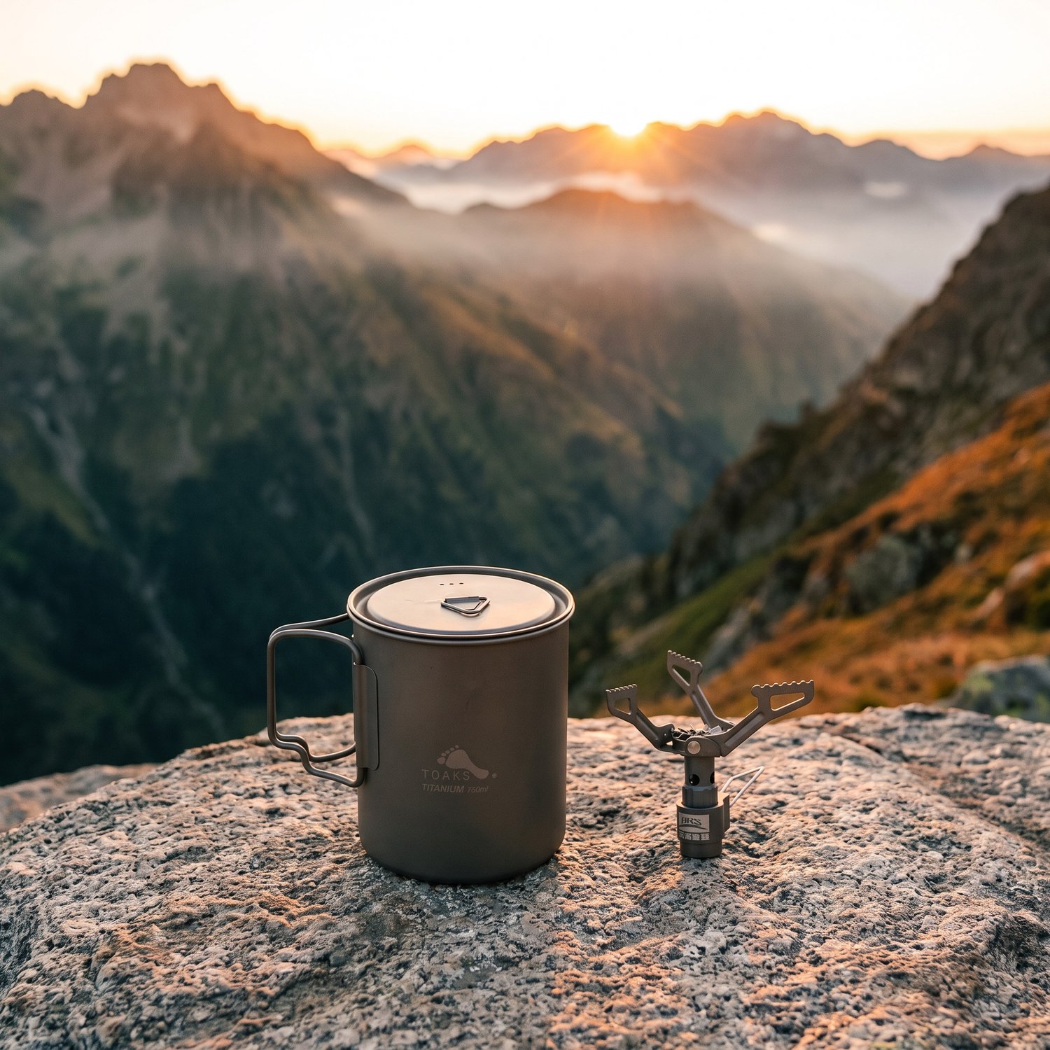 Pot en titane TOAKS 750 ml et réchaud à gaz BRS-3000T replié sur un rocher, vallée au lever du jour