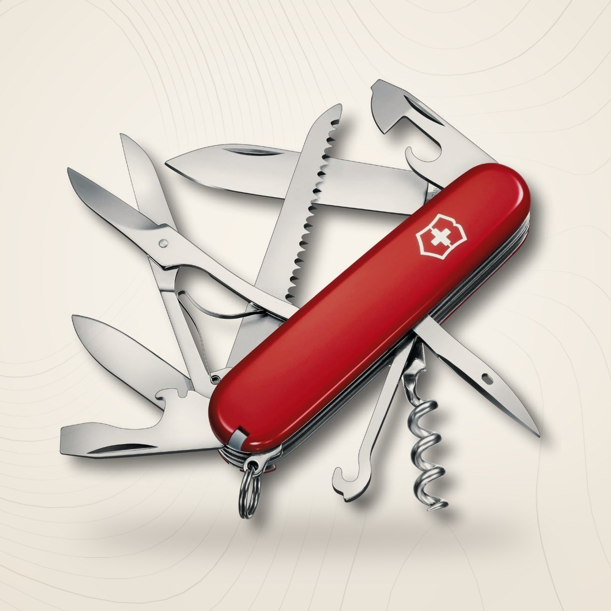 Couteau suisse Victorinox Huntsman rouge ouvert, scie, ciseaux, lames et tire-bouchon déployés, sur fond lin