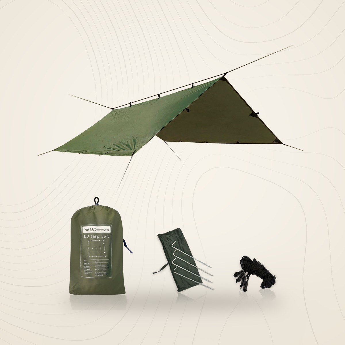 Tarp 3x3 DD Hammocks vert forêt monté en toit, avec son sac, ses quatre piquets et ses haubans, sur fond lin