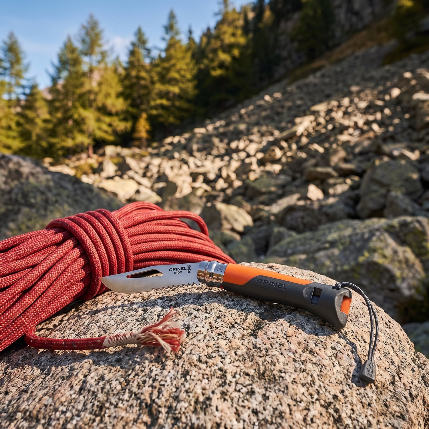 Opinel N°8 Outdoor ouvert sur un bloc de granit, près dune corde descalade lovée, au pied des dalles en fin de matinée