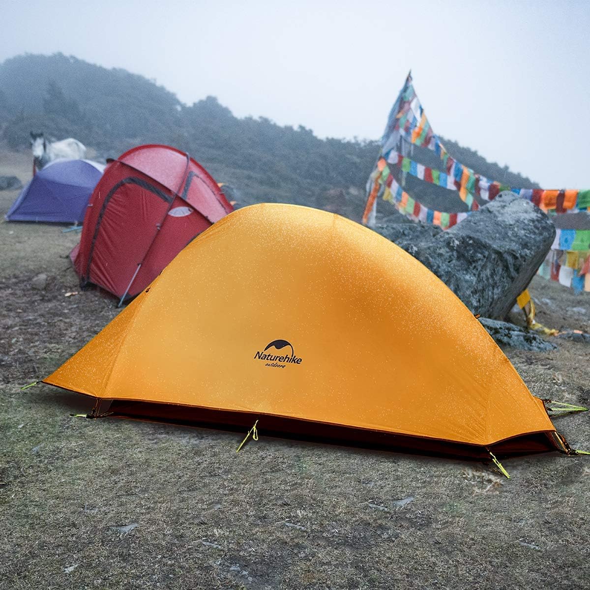Tente Naturehike Cloud-Up 1 plantée sur un replat daltitude, un jour de brouillard