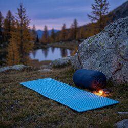 Matelas Therm-a-Rest Z Lite Sol déplié sur l'herbe d'un alpage à la tombée de la nuit, près d'un rocher