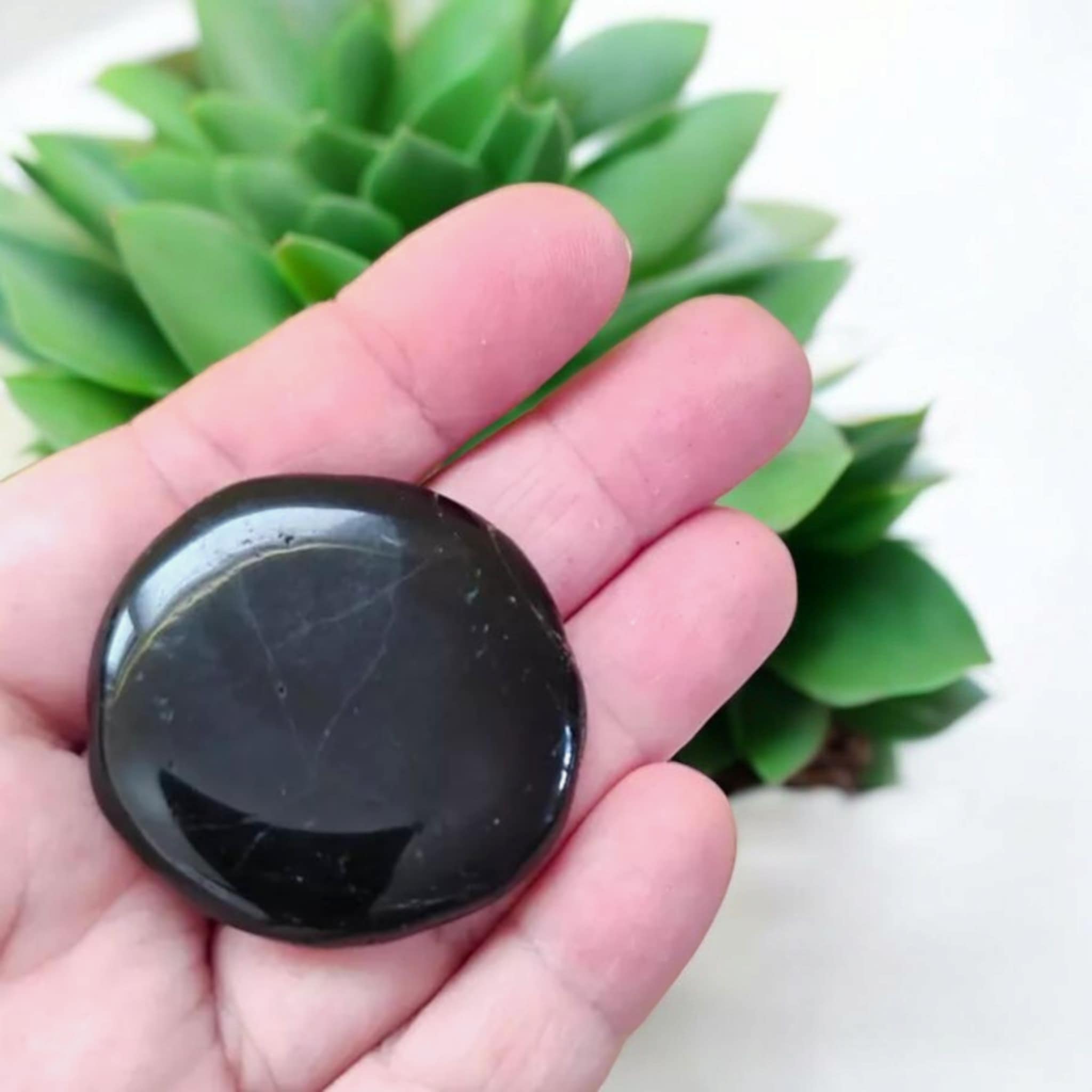 Galet poli de Tourmaline Noire Schorl tenu en main