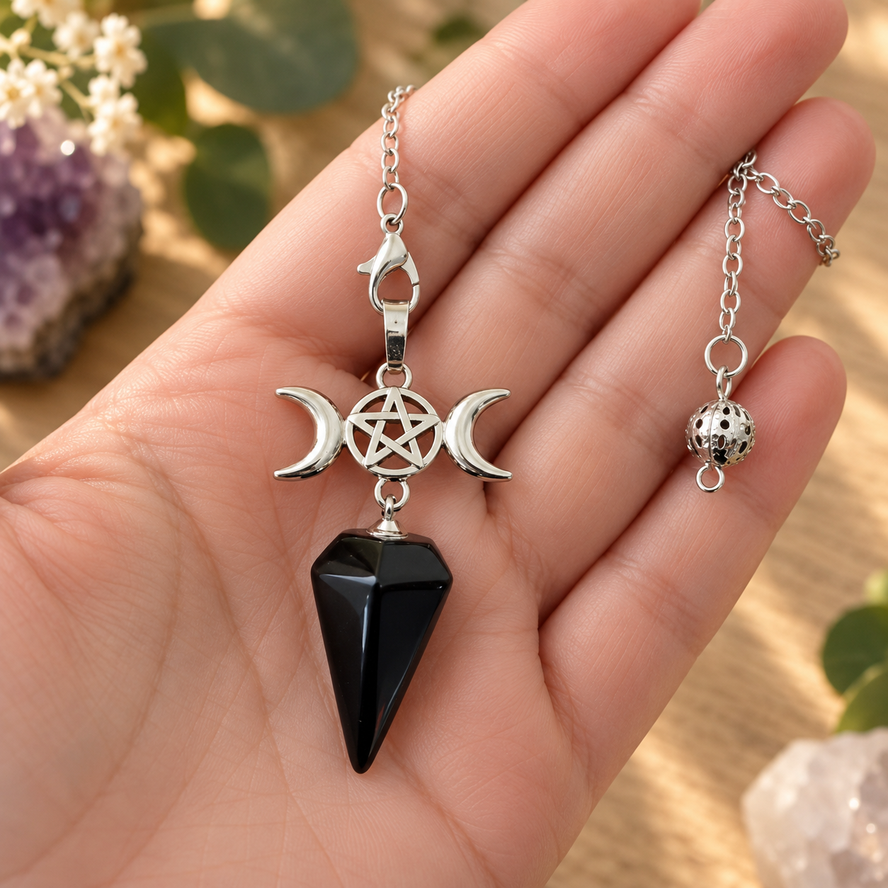 Pendule Triple Lune en Obsidienne noire tenu en main