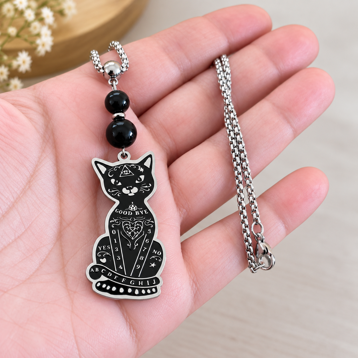 collier-chat-ouija-arcan-charme-trefonds-tenu-en-main