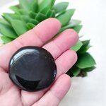 Galet poli de Tourmaline Noire Schorl tenu en main