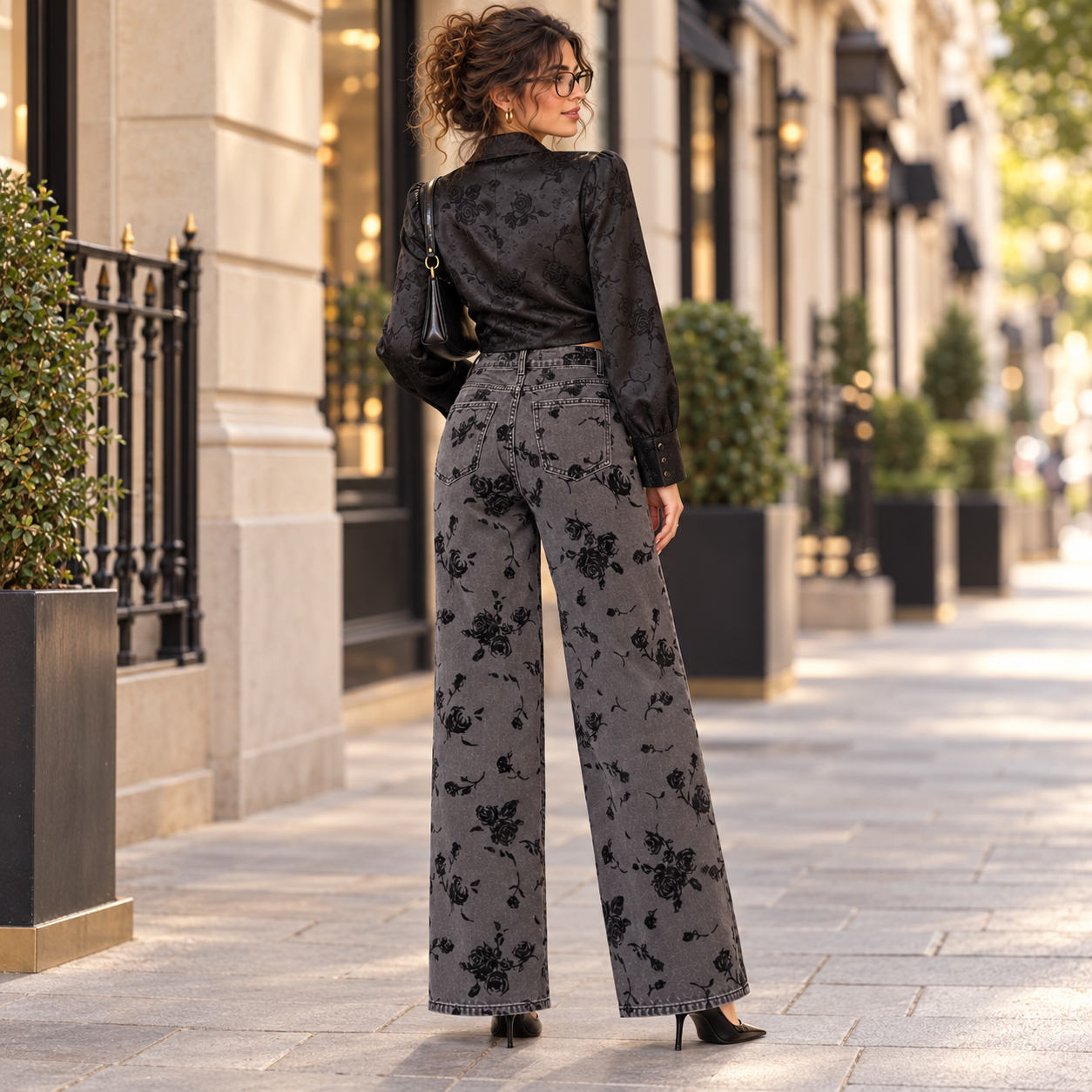 Vue de dos du jean wide leg gris anthracite fleuri, poches arrière et jambes larges, en ville.