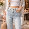 Zoom sur la ceinture en dentelle et les perles à l'avant du jean large.