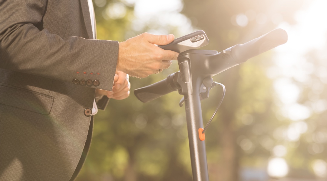 homme trottinette et telephone