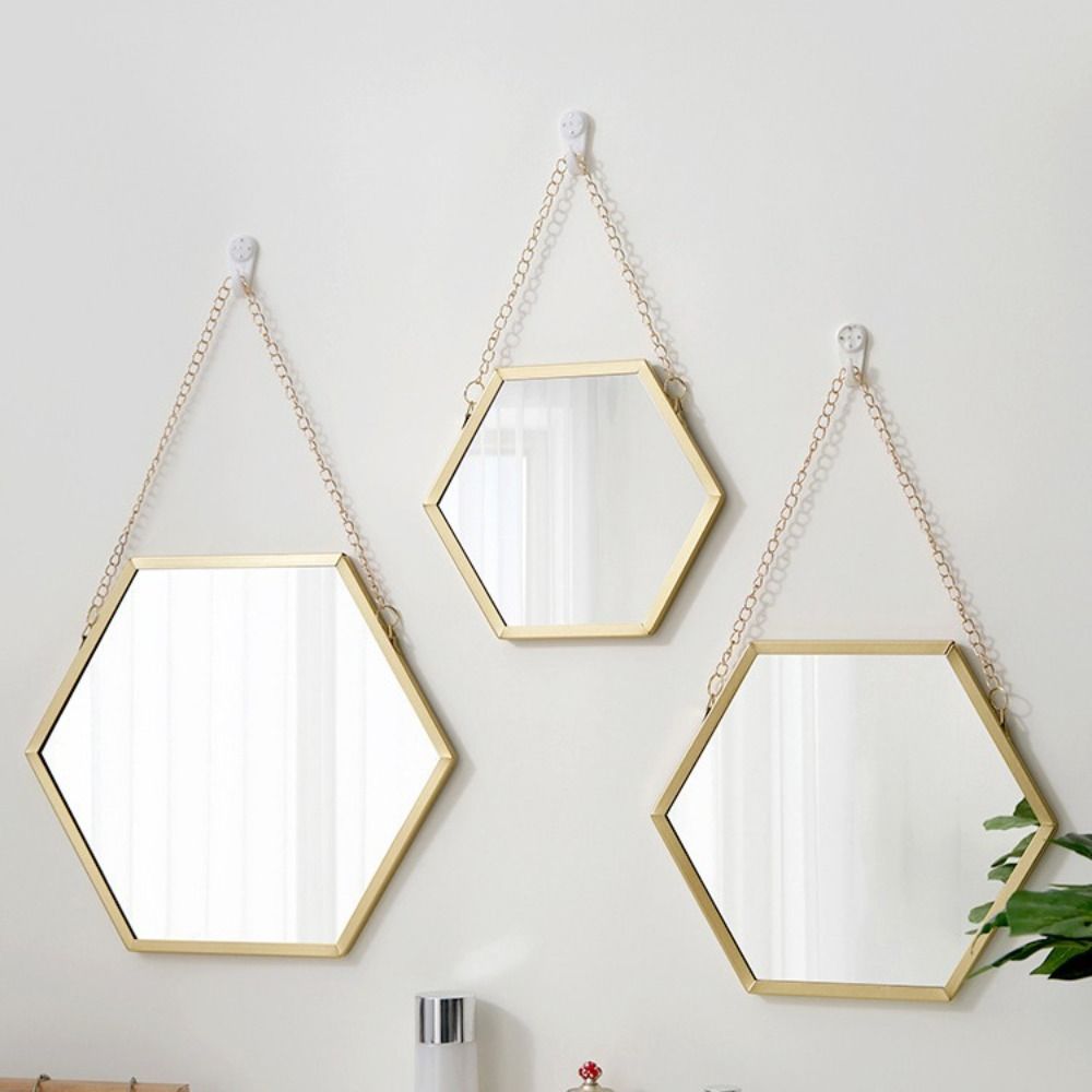Miroir mural hexagonal avec cadre en métal doré