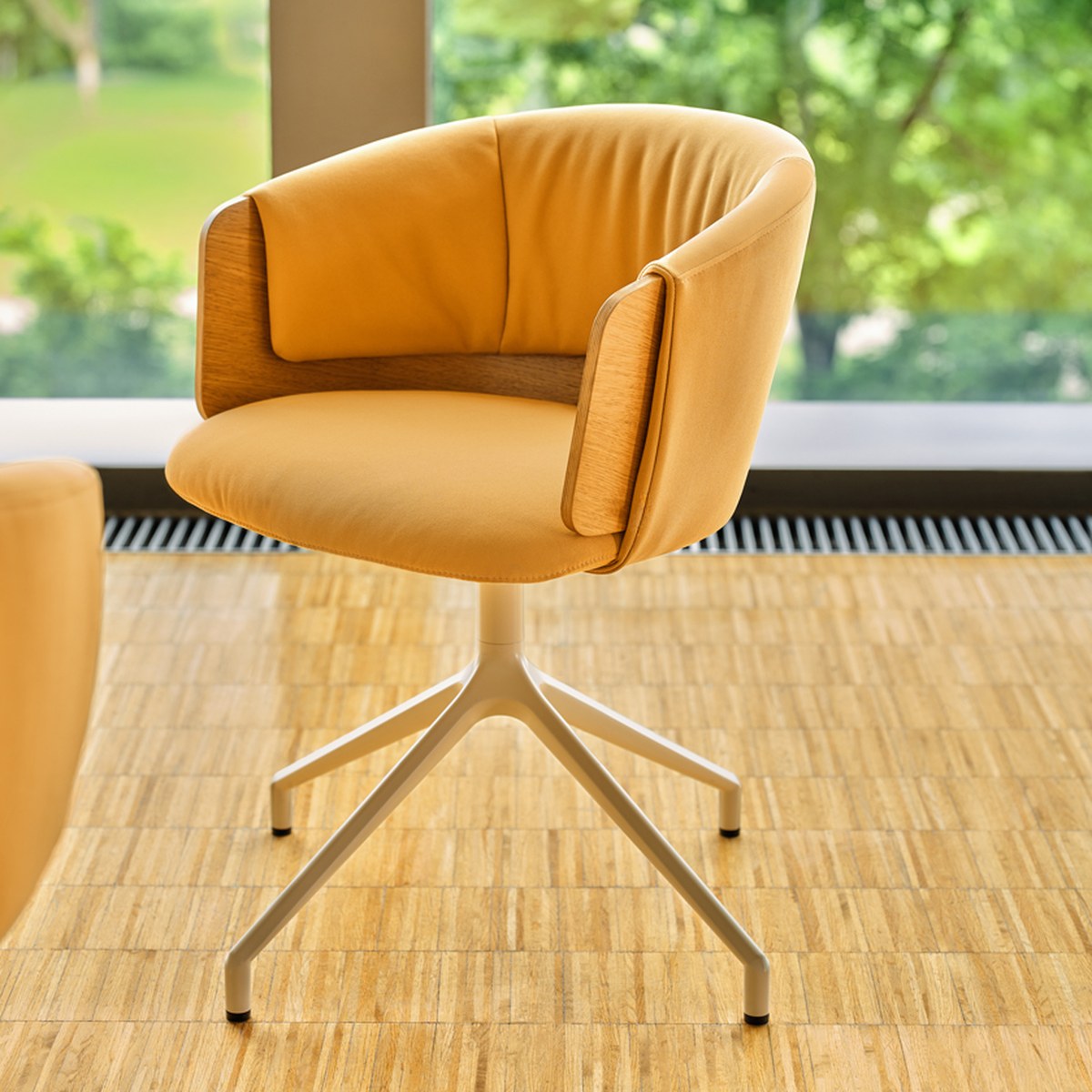 Chaise pivotante tapissée ocre à dossier drapé et placage chêne, vue de trois quarts sur parquet