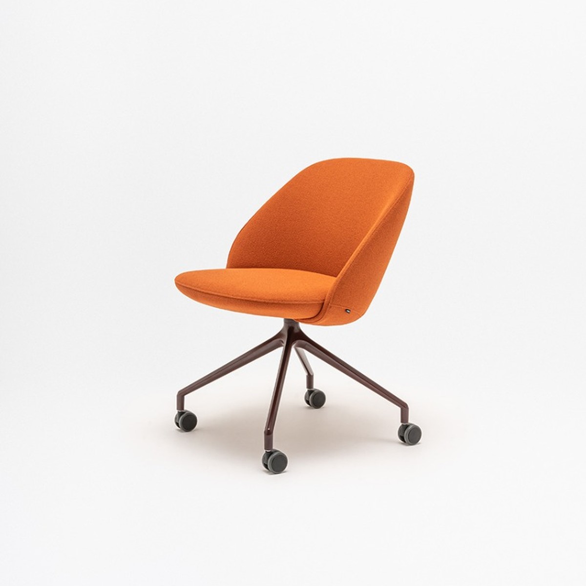 Fauteuil tapissé orange à dossier bas, piétement bordeaux sur roulettes, vue de trois quarts